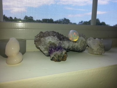 This is my simple little altar! I have candles on each side and a little snake statue because I read somewhere that the snake is associated with the God. I am going to get a flower for the Goddess today. I have a little amethyst because it is my birthstone color. I don't know why I put the piece of opalite on the clear quartz but it looks nice there X).